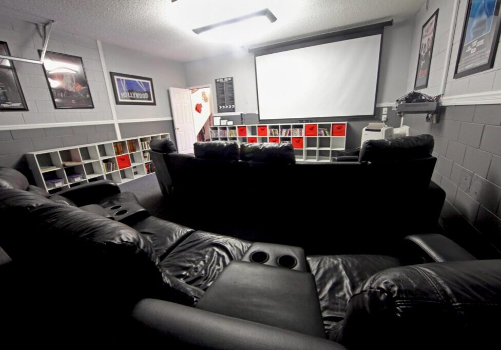 a room with a lot of couches and a projector screen
